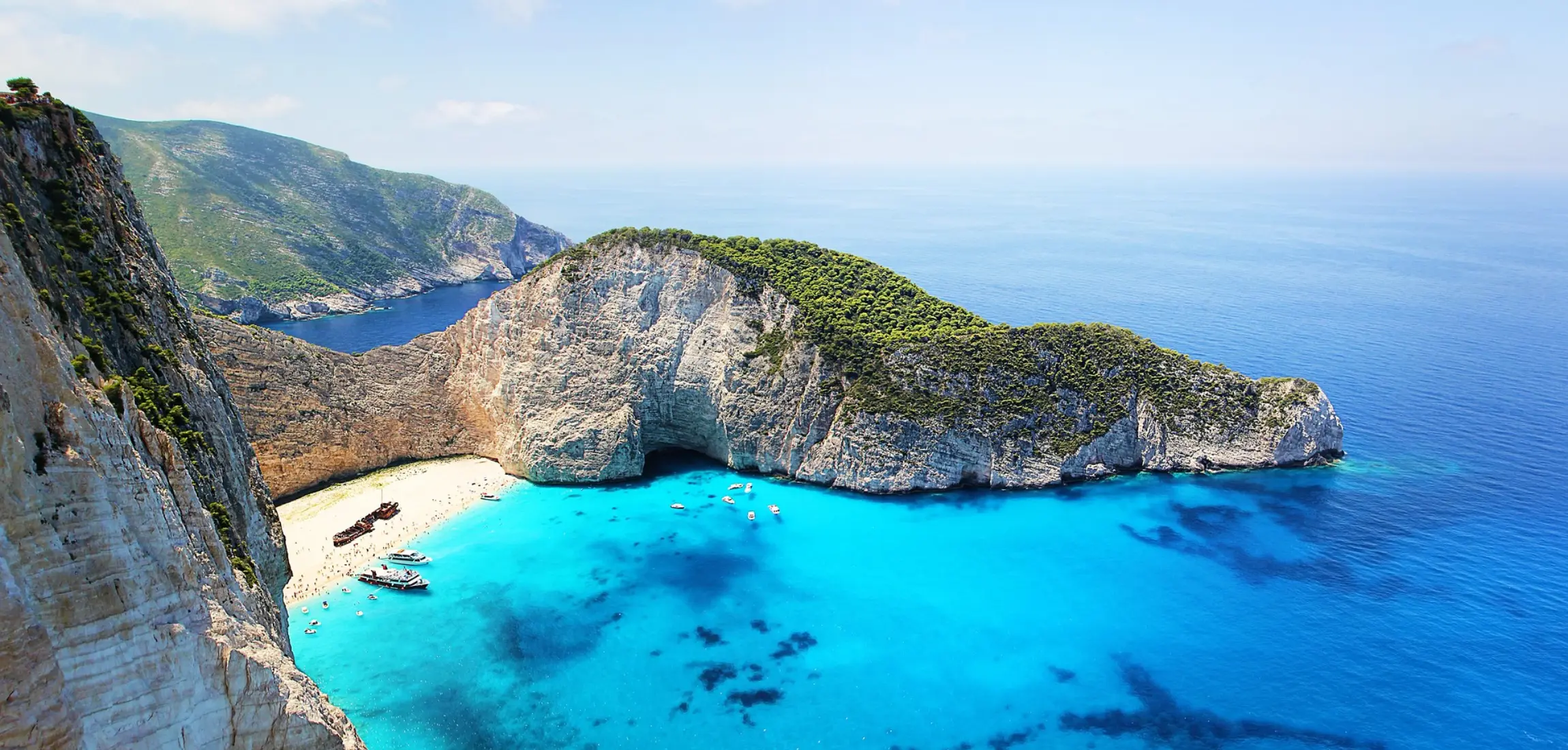 Ontdek de mooiste stranden van Griekenland met FlowyTravel, zoals Navagio Beach op Zakynthos met helderblauw water.
